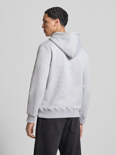 Männermodel trägt Slim Fit Hoodie mit Logo-Stitching von REVIEW in lichtgrijs, katoenmix, elastisch, kangoeroezak, ruglengte maat M 66 cm, mouwlengte 63 cm, ganzkörperansicht rückansicht