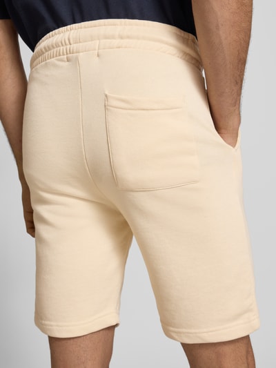 Männermodel trägt Sweatshorts mit elastischem Bund Modell 'KARLOS' von Blend, beigefarbener Baumwoll-Mix, Regular Fit, Ganzkörperansicht Rückansicht.