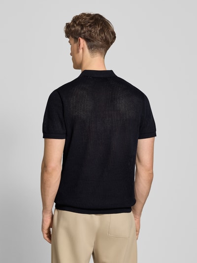 Männermodel trägt Modern Fit Poloshirt mit kurzer Knopfleiste Modell 'JESS' von Jack & Jones aus Baumwoll-Mix, semitransparentes Design, schwarze Farbe, glatte und feine Maschenstruktur, Polokragen, Rückenlänge bei Größe M 68 cm, Ganzkörperansicht Rückansicht.