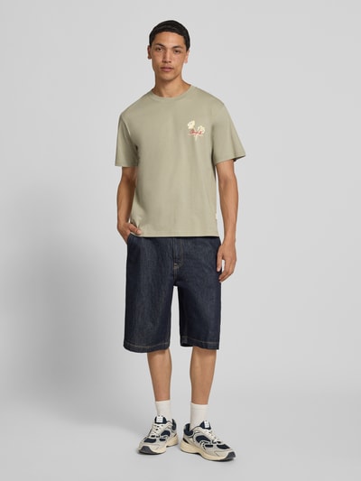 Mannmodel draagt T-shirt met motiefprint en ronde hals van Jack & Jones, heren T-shirt van puur katoen, regular fit, ruglengte maat M 70 cm, Ganzkörperansicht von vorne.