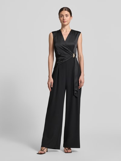Vrouwenmodel draagt Regular Fit Jumpsuit met Zierbesatz van Rinascimento, zwart, satijn, v-hals, mouwloos, taillering, sierdetail, wikkel-look, plooien, elastisch materiaal-mix, volledige lichaamsweergave van voren.