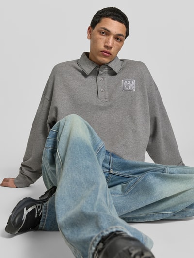 Männermodel trägt Regular Fit Pullover mit Polokragen von MAISON KITSUNÉ aus reiner Baumwolle, Logo-Stitching, elastische Abschlüsse, Ganzkörperansicht Vorderansicht.