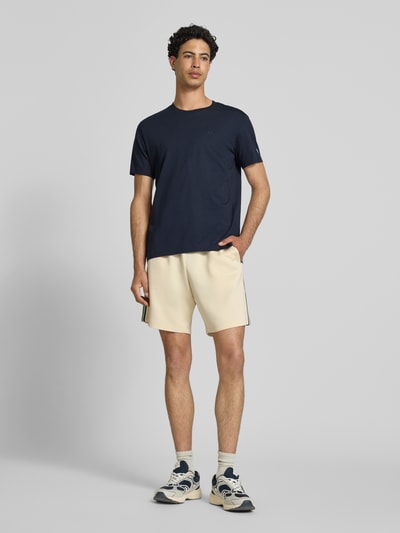 Männermodel trägt T-Shirt mit Label-Stitchings und Rundhalsausschnitt von CHAMPION, dunkelblau, Reine Baumwolle, Regular-Fit, Ganzkörperansicht von vorne. Rückenlänge bei Größe M: 66 cm.