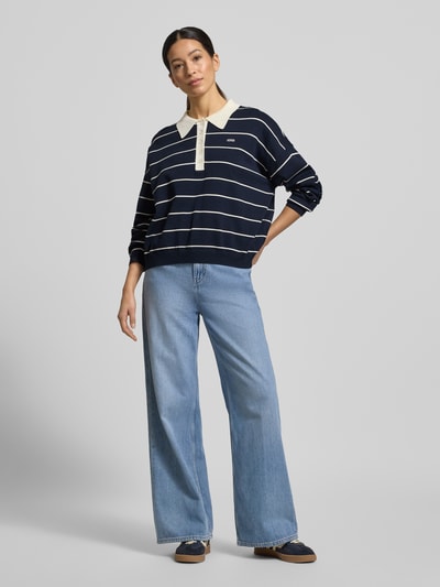 Frauenmodel trägt Strickpullover mit Polokragen Modell 'taige' von Gestuz, Viskose-Mix, Oversized, navy mit weißen Streifen, Ganzkörperansicht von vorne.