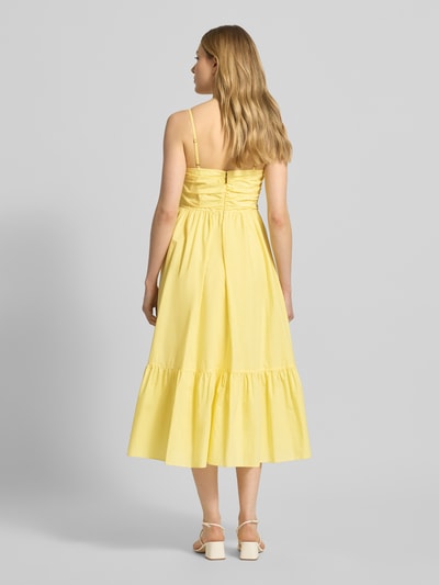 Frauenmodel trägt Midikleid mit Volantsaum und V-Ausschnitt von MICHAEL Michael Kors, Reine Baumwolle, A-Linie, Ganzkörperansicht Rückansicht.