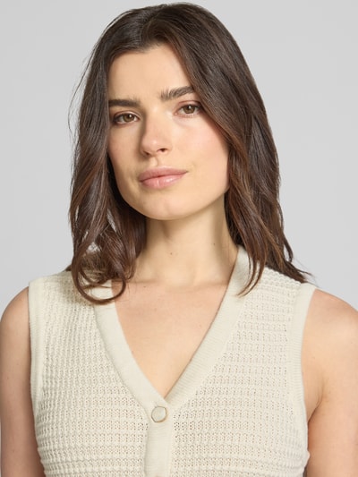 Frauenmodel trägt Strickweste mit V-Ausschnitt Modell 'MIKALA' von B.Young aus reiner Baumwolle, Regular-Fit, Knopfleiste, Nahaufnahme Oberkörper.
