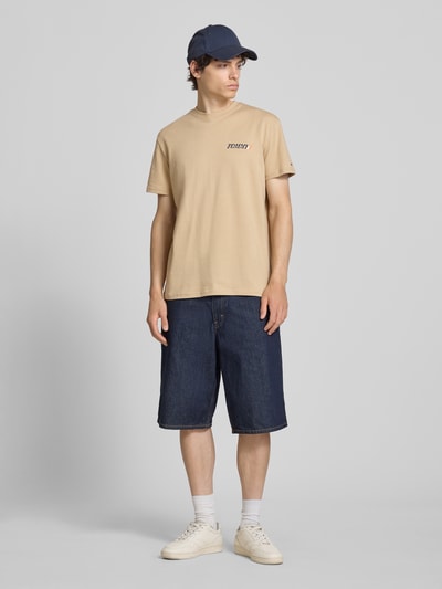 Männermodel trägt Regular Fit T-Shirt aus reiner Baumwolle von Tommy Jeans, Optik: Unifarben, Label-Print, Rundhals-Ausschnitt, Ärmelform: Kurzarm, Materialverarbeitung: Jersey, Material: reine Baumwolle, Ganzkörperansicht von vorne.