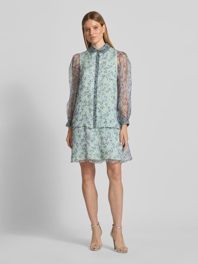 Kobiece modelka nosi Knielanges Kleid aus Seide mit Knopfleiste von Marc Cain, jasne kolory, wzór na całej powierzchni, półprzezroczysty materiał, prosty krój, długość do kolan, kołnierzyk koszulowy, listwa guzikowa, długość tyłu w rozmiarze 36: 94 cm, szerokość w rozmiarze 36: 50 cm, długość rękawów w rozmiarze 36: 64 cm, widok całej sylwetki z przodu.