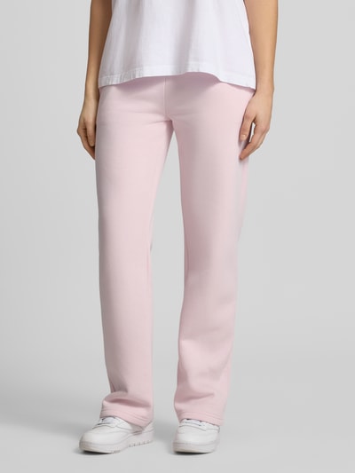 Frauenmodel trägt Sweatpants mit elastischem Bund Modell 'Iconic' von Gina Tricot in Rosa aus Baumwoll-Mix, Relaxed-Fit, Ganzkörperansicht von vorne. Damen Sweatpants, Innenbeinlänge bei Größe S 80 cm.
