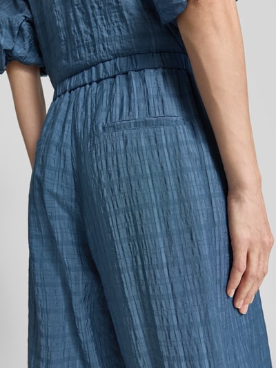Frauenmodel trägt Stoffhose mit elastischem Bund von Jake*s Casual in Blau, lockerer Schnitt, Gesäßtaschen, Detailaufnahme Rückenpartie.