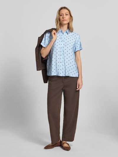 Vrouwenmodel draagt Regular Fit Blouse uit viscosemix in all-over look van Jake*s Casual, lichtblauw met zwarte stippen, overhemdkraag, mouwen met omslag, ruglengte maat 36: 61 cm, mouwlengte maat 36: 17 cm, full-body vooraanzicht.