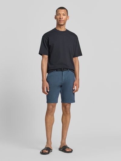 Männermodel trägt Regular Fit Chinoshorts aus Baumwoll-Mix von Tom Tailor Denim, Bi-Color Optik, Gürtelschlaufen, Ganzkörperansicht von vorne.