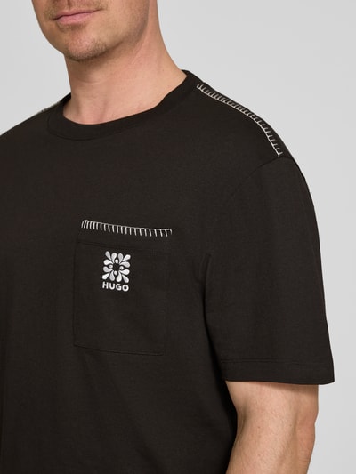 Männermodel trägt Regular Fit T-Shirt aus reiner Baumwolle Modell 'DARRO' von HUGO, Optik: Unifarben, Label-Schriftzug, Jersey, Nahaufnahme Oberkörper