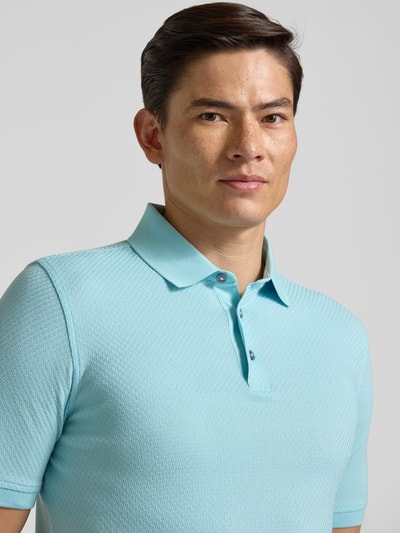 Männermodel trägt Slim Fit Poloshirt mit Strukturmuster von bugatti in Hellblau, Reine Baumwolle, Knopfleiste, Nahaufnahme Oberkörper. Rückenlänge 73 cm bei Größe M.