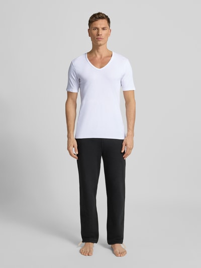 Männermodel trägt T-Shirt mit V-Ausschnitt von MCNEAL aus weißem Baumwoll-Mix mit Stretch-Anteil, Regular-Fit, Teilungsnähte, Ganzkörperansicht von vorne.