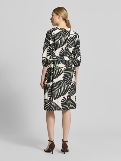 Frauenmodel trägt Knielanges Kleid aus Viskose-Mix mit Tunika-Ausschnitt von Christian Berg Woman Selection, floraler Allover-Print, taillierte Passform, Knielänge, Halbarm, Ganzkörperansicht Rückansicht.