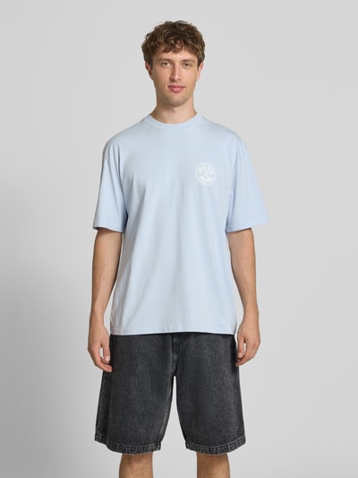 Männermodel trägt Oversized T-Shirt mit Label-Print von Pegador in Hellblau aus Reine Baumwolle, Rundhalsausschnitt, Herren T-Shirt, Ganzkörperansicht von vorne. Rückenlänge bei Größe M: 72 cm.