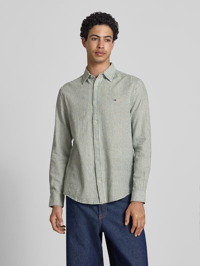 Männermodel trägt Regular Fit Freizeithemd aus Leinen-Baumwoll-Mix von Tommy Jeans, Mehrfarbig, Gestreift, Flammgarn, Ganzkörperansicht von vorne.