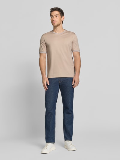 Männermodel trägt T-Shirt mit Rundhalsausschnitt von bugatti in Beige, aus Baumwoll-Mix, Regular-Fit, Label-Detail, Ganzkörperansicht von vorne. Rückenlänge bei Größe M: 70 cm.
