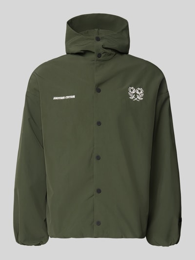 Produktfoto, Adventure Jacke mit Kapuze und verstellbarem Saum von ANOTHER COTTON LAB, zieleniona, prosta forma, matowa tekstura, krój regular fit, kaptur, stójka, napy, nadruki z logo, naszywka, regulowany dół ze sznurkiem, długość tyłu w rozmiarze M: 70 cm, szerokość ramion w rozmiarze M: 60 cm, szerokość klatki piersiowej w rozmiarze M: 64 cm, długość rękawa w rozmiarze M: 53 cm
