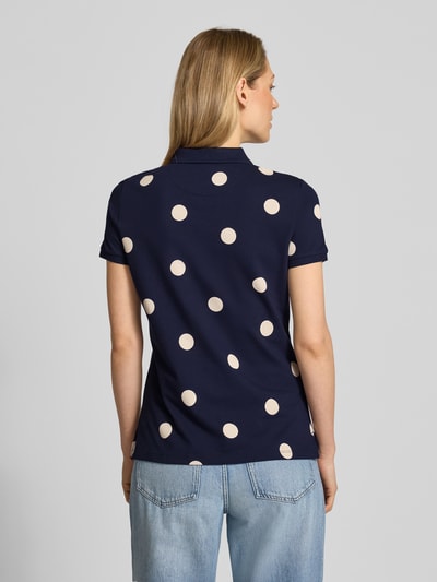 Modelka kobieca nosi Poloshirt mit kurzer Knopfleiste von Christian Berg Woman, granatowy z jasnymi groszkami, bawełna z elastanem, dopasowany krój, widok całej sylwetki od tyłu.