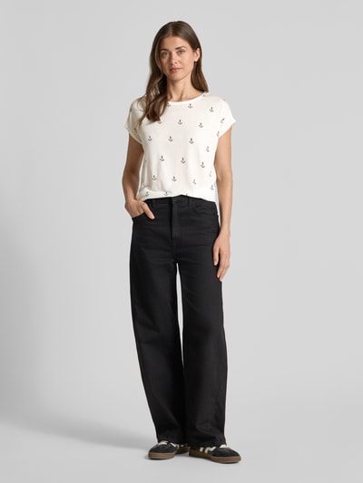 Frauenmodel trägt Relaxed Fit T-Shirt aus Lyocell-Mix Modell 'AVA' von Vero Moda mit Optik:Allover-Muster, Allover-Print, Rundhals, Kurzarm, Ärmelabschluss fixierter Umschlag, Ganzkörperansicht von vorne.