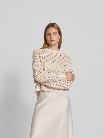Frauenmodel trägt Relaxed Fit Pullover mit Lochmuster von Juvia in Creme, reine Baumwolle, elastische Abschlüsse, Nahaufnahme Oberkörper.