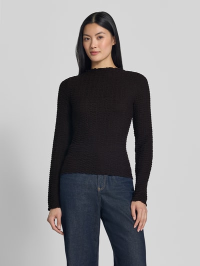 Frauenmodel trägt schwarzes Regular Fit Langarmshirt aus Baumwoll-Mix Modell 'ZIA' von VERO MODA, Damen Langarmshirt, Ganzkörperansicht von vorne.