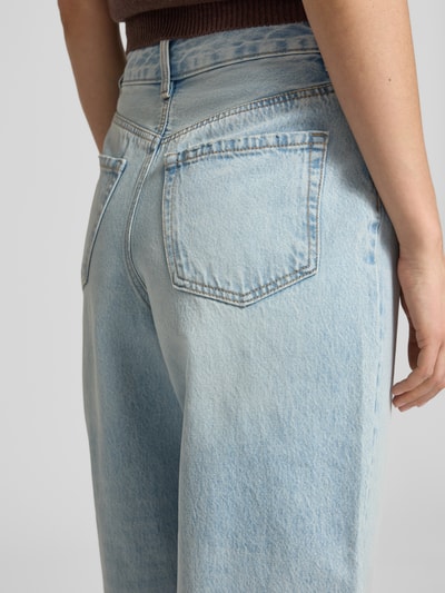 Vrouwenmodel draagt Barrel Fit Wide Leg Jeans uit puur katoen model 'BILLIE' van Vero Moda in lichtblauwe denim met twillstructuur, high waist, 5-pocket-design, knoopsluiting en nieten, detailopname achterkant.