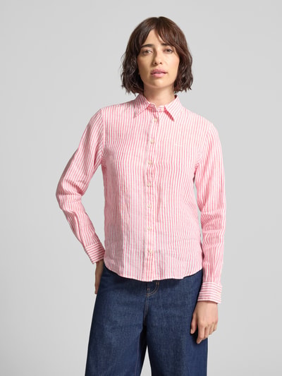 Vrouwenmodel draagt Regular Fit linnen blouse met overhemdkraag en labelstitching van Gant, roze-wit gestreept, dames, vooraanzicht, Ganzkörperansicht von vorne. Ruglengte maat 36: 66 cm, mouwlengte maat 36: 61 cm.