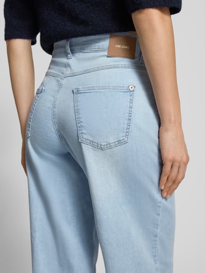 Männermodel trägt Wide Fit Jeans-Culotte aus mieszanka bawełny i modalu Modell 'DREAM' von MAC w jasnoniebieskim kolorze, naszywka z logo, 5 kieszeni, zapięcie na guzik i zamek błyskawiczny, szerokość w rozmiarze 36: 39 cm, długość wewnętrzna nogawki 68 cm, zakończenia nogawek z wystrzępieniami, widok z tyłu, detailaufnahme.