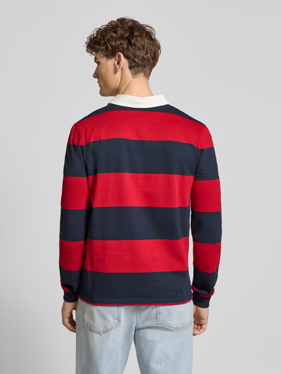 Männermodel trägt Regular Fit Poloshirt mit Rugby-Streifen und Logo-Bestickung von REVIEW, rote und dunkelblaue Querstreifen, Rückenansicht.