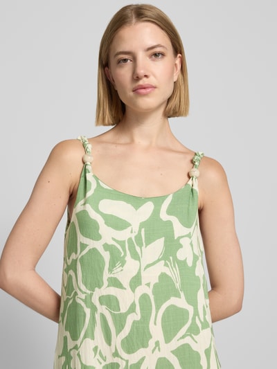 Frauenmodel trägt Midikleid aus Viskose-Mix Modell 'El44ora' von ZABAIONE, grün-weißes A-Linien-Design mit Allover-Muster, Nahaufnahme Oberkörper.