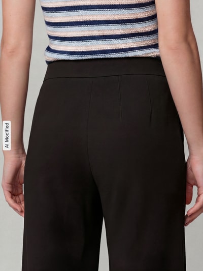 Frauenmodel trägt Regular Fit Weite Hose aus Viskose-Mix Modell 'NALEY' von SEDUCTIVE, schwarze Farbe, Damen Weite Hose, Nahaufnahme Rückansicht.