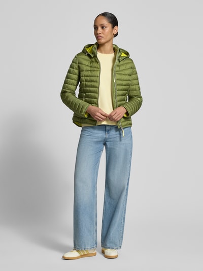 Frauenmodel trägt Steppjacke mit Zweiwege-Reißverschluss von Fuchs Schmitt in Grün, Kapuze, Stehkragen, Reißverschlusstaschen, Regular Fit, Ganzkörperansicht von vorne.