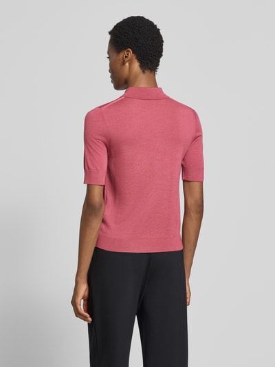 Frauenmodel trägt Regular Fit Poloshirt aus reiner Schurwolle Modell 'Fidenka' von BOSS in Rosa und Schwarz, Ganzkörperansicht Rückansicht, Damen Poloshirt von BOSS.