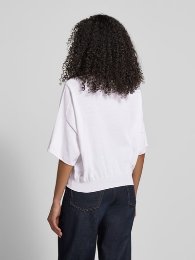 Modelka kobieca nosi Strickshirt mit Rundhalsausschnitt Modell 'DILARY' od Drykorn z bawełny, krój relaxed fit, zrolowany brzeg, długość tyłu 53 cm, długość rękawów 33 cm, widok całej sylwetki z tyłu.