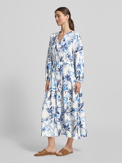 Frauenmodel trägt Midikleid aus Viskose-Mix im Allover-Look von ROBE LÉGÈRE in Weiß und Blau, A-Linie, V-Ausschnitt, Ganzkörperansicht von vorne.