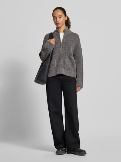 Vrouwenmodel draagt Regular Fit Strickjacke aus Woll-Mix Modell 'SIA' van Selected Femme, grijs, zachte textuur, rechte vormen, dames vest, volledig frontaal zicht.