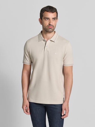 Männermodel trägt Regular Fit Poloshirt mit Label-Stitching von Fynch-Hatton in Beige, reine Baumwolle, Knopfleiste, Ganzkörperansicht von vorne.