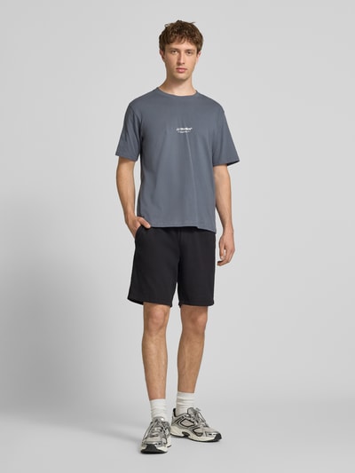 Mannenmodel draagt Shorts met structuurpatroon model 'JAIDEN' van Jack & Jones van puur katoen in regular fit met elastische band en tunnelkoord, bandwijdte maat M 43 cm, binnenbeenlengte maat M 23 cm, zwart, textuur zichtbaar, volledige lichaamsaanzicht van voren.