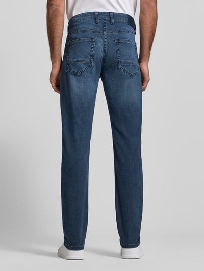 Männermodel trägt Straight Fit Jeans aus Baumwoll-Mix von MAC in Blau mit Kontrastnähten, 5-Pocket-Design, Ganzkörperansicht Rückansicht.
