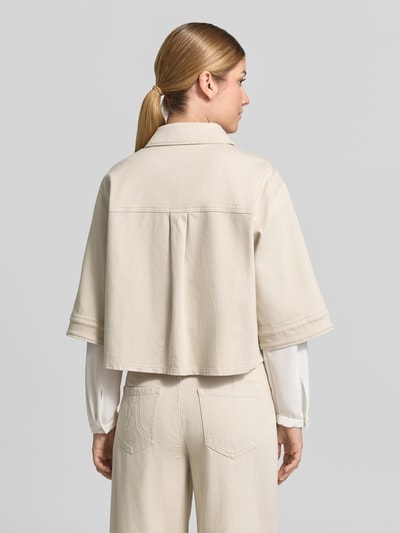 Frauenmodel trägt Relaxed Fit Blazer aus Baumwoll-Mix in Denim-Optik von Marc Cain in Beige mit Umlegekragen und 1/2-Arm, Ganzkörperansicht Rückansicht. Elastischer Baumwoll-Mix, durchgängige Knopfleiste, Rückenlänge 52 cm, Brustweite 55 cm, Ärmellänge 34 cm.