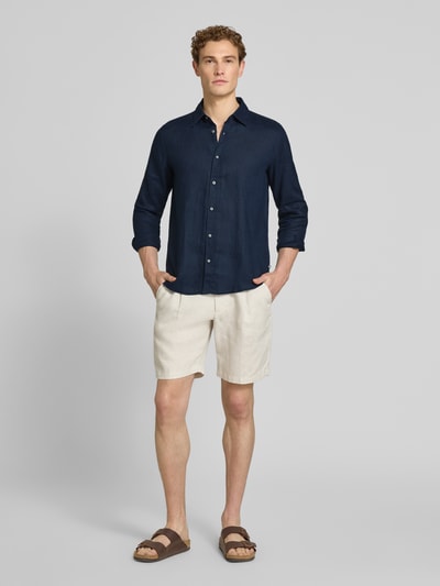 Männermodel trägt Regular Fit Freizeithemd aus reinem Leinen von s.Oliver RED LABEL in Dunkelblau, unifarben, Knopfleiste, Ganzkörperansicht von vorne.