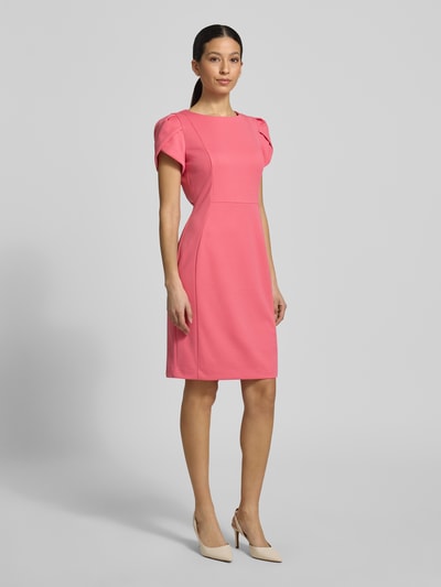 Frauenmodel trägt Knielanges Cocktailkleid mit Rundhalsausschnitt von Vera Mont in Pink, Material-Mix mit Stretch-Anteil, Gerader-Schnitt, Knielänge, kurze Ärmel, schlichte Struktur, Ganzkörperansicht von vorne. Rückenlänge bei Größe 36: 97 cm, Brustweite: 44 cm, Ärmellänge: 18 cm.