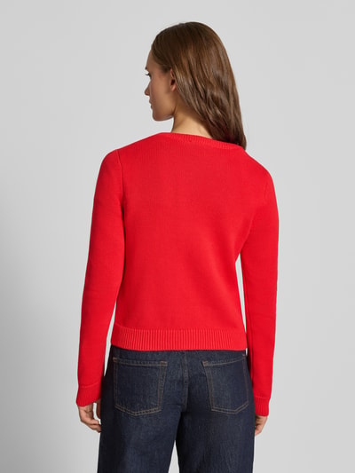 Frauenmodel trägt Slim Fit Pullover aus reiner Baumwolle von REVIEW in Strick-Optik, rote Farbe, Rückenansicht, Nahaufnahme Oberkörper.