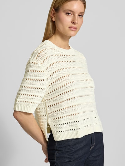 Kobiece model nosi Regular Fit Sweatshirt mit Lochmuster Modell 'Mina' von OPUS aus mieszanka bawełny, kolor kremowy, rękaw o dł. 1/2, okrągły dekolt, elastyczne wykończenia, widoczne perforowanie, długość tyłu w rozmiarze S 51 cm, długość rękawów w rozmiarze S 61 cm, widok na cały tułów z przodu.