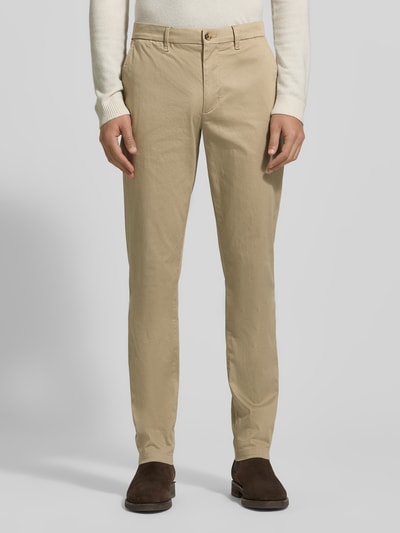 Männermodel trägt Slim Fit Chino aus Baumwoll-Mix Modell 'BLEECKER' von Tommy Hilfiger in Beige, unifarben, Ganzkörperansicht von vorne.