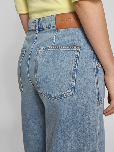 Frauenmodel trägt Flared Leg Jeans aus reiner Baumwolle Modell 'CAYA' von Marc O'Polo, Denim-Optik, Label-Patch, Ganzkörperansicht Rückansicht.