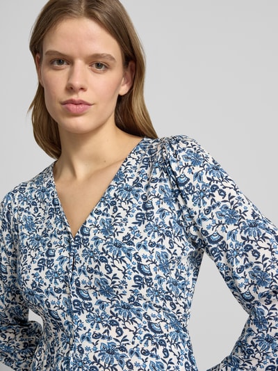 Frauenmodel trägt tailliertes Freizeitkleid aus reiner Viskose Modell 'EVIDA' von Only mit Allover-Muster in Blau und Weiß, Nahaufnahme Oberkörper.
